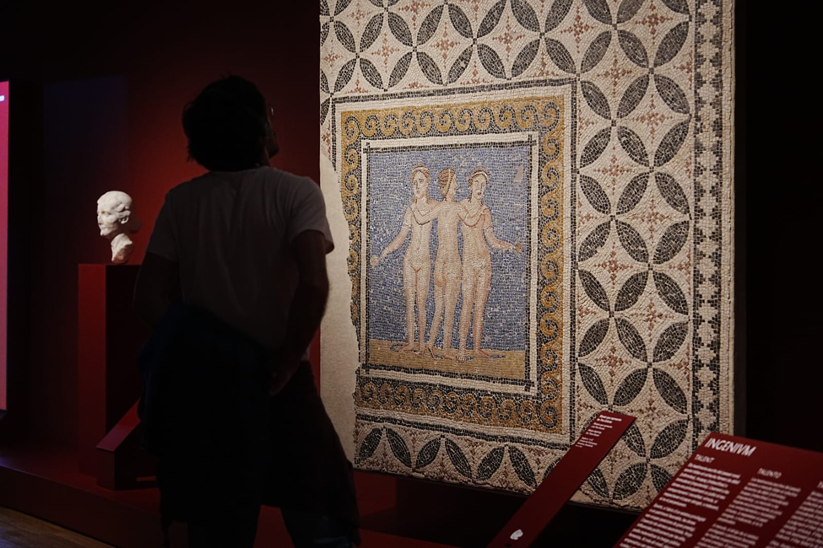 Un visitant observa un mosaic romà en una exposició. 