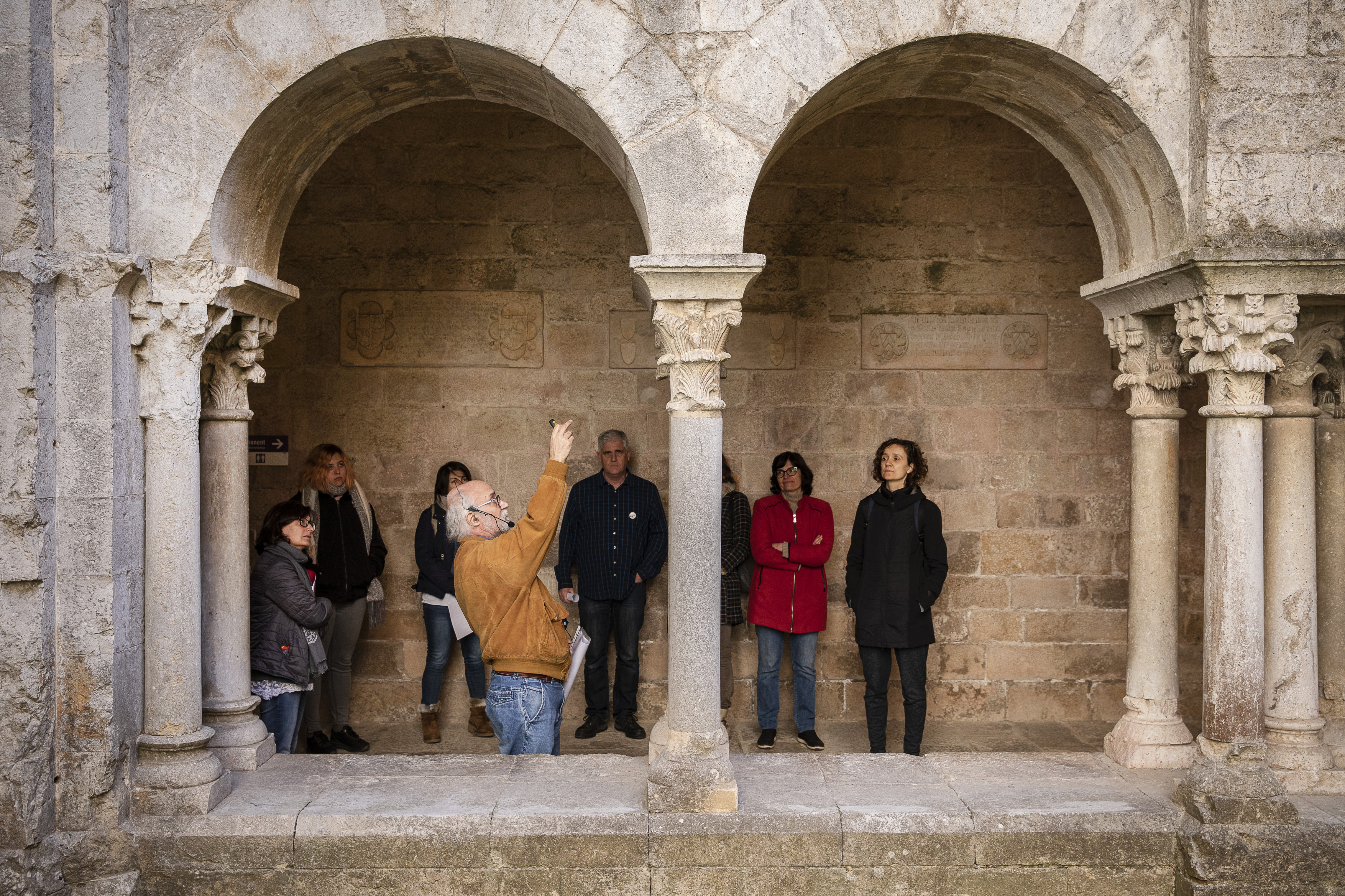 Una visita guiada en el claustre d'un monestir romànic.