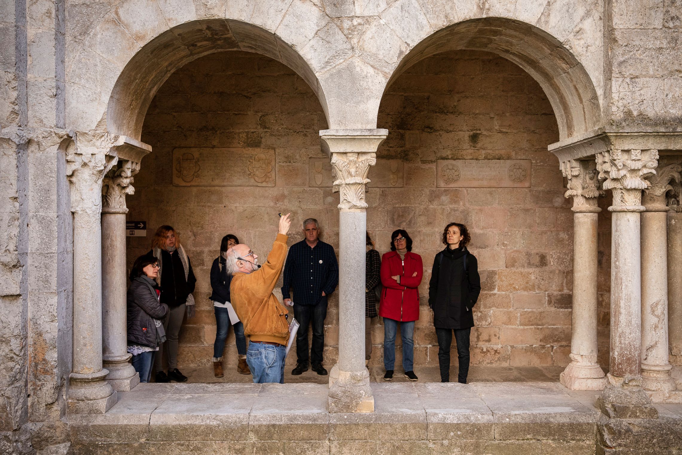 Una visita guiada en el claustre d'un monestir romànic.