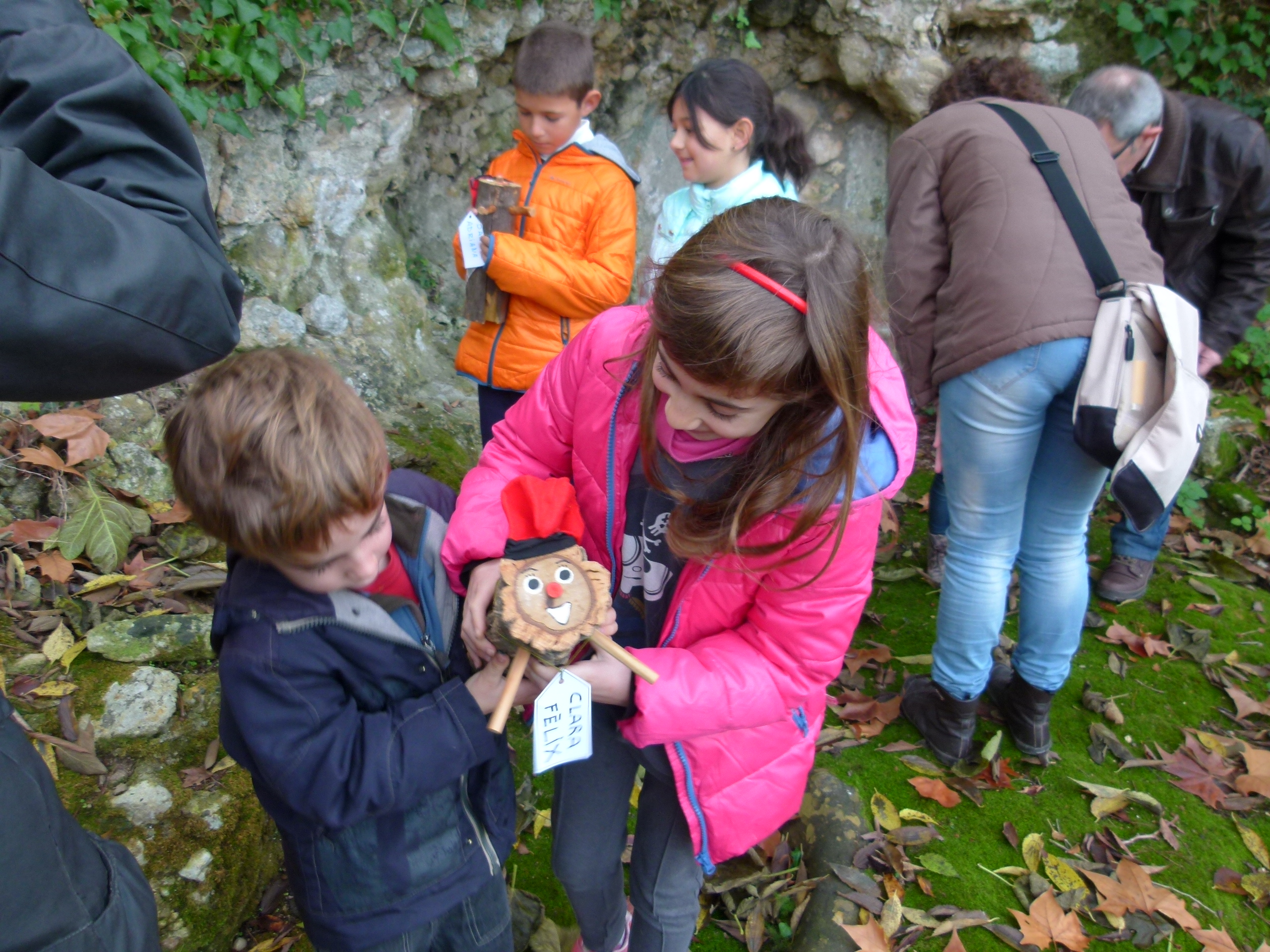 Dos infants agafant un Tió en una activitat.