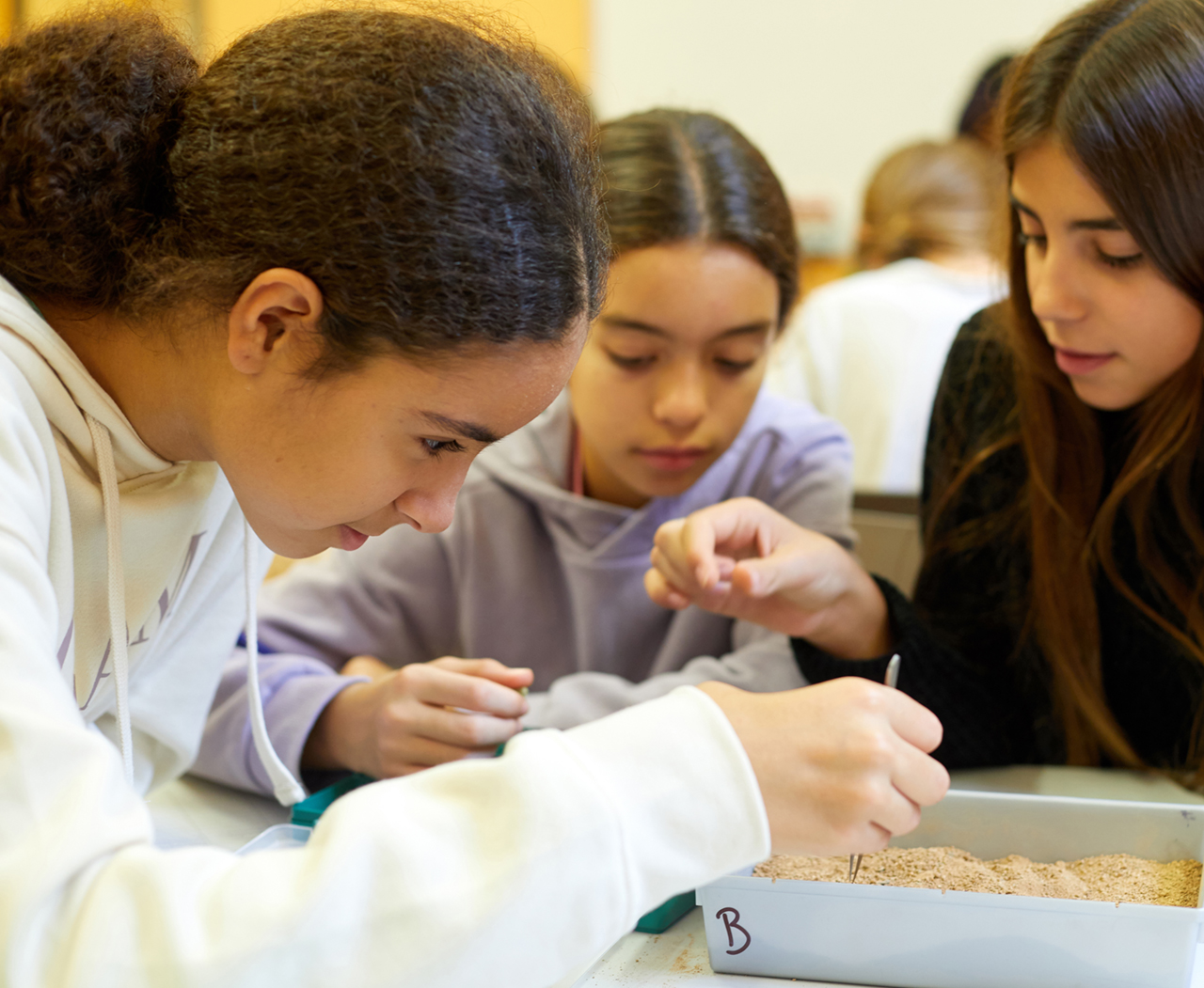 Tres noies fent una activitat escolar