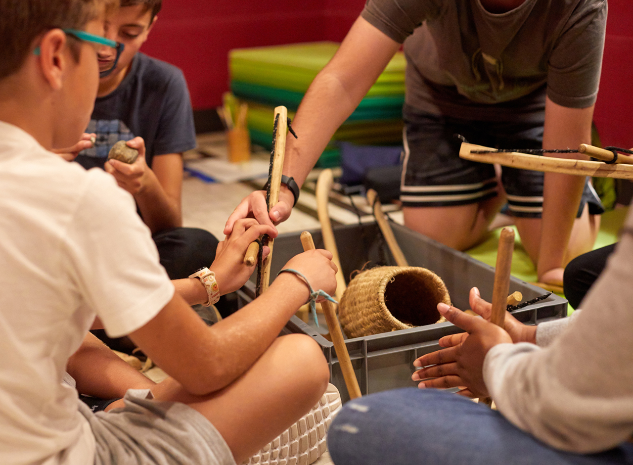 Infants fent un taller d'experimentació amb eines prehistòriques