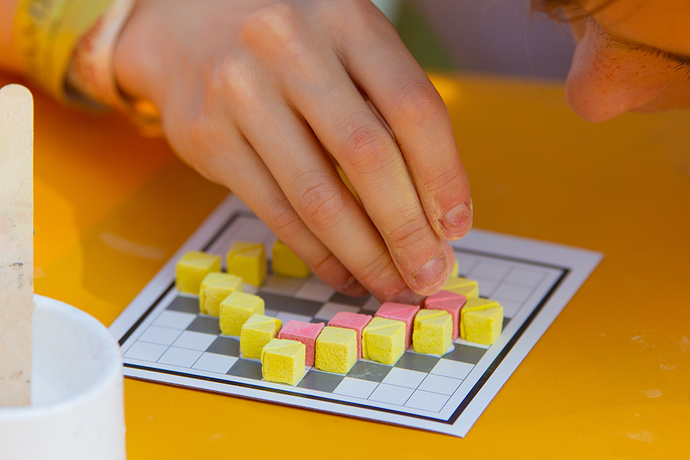 Detall d'una mà fent un patró de mosaic.