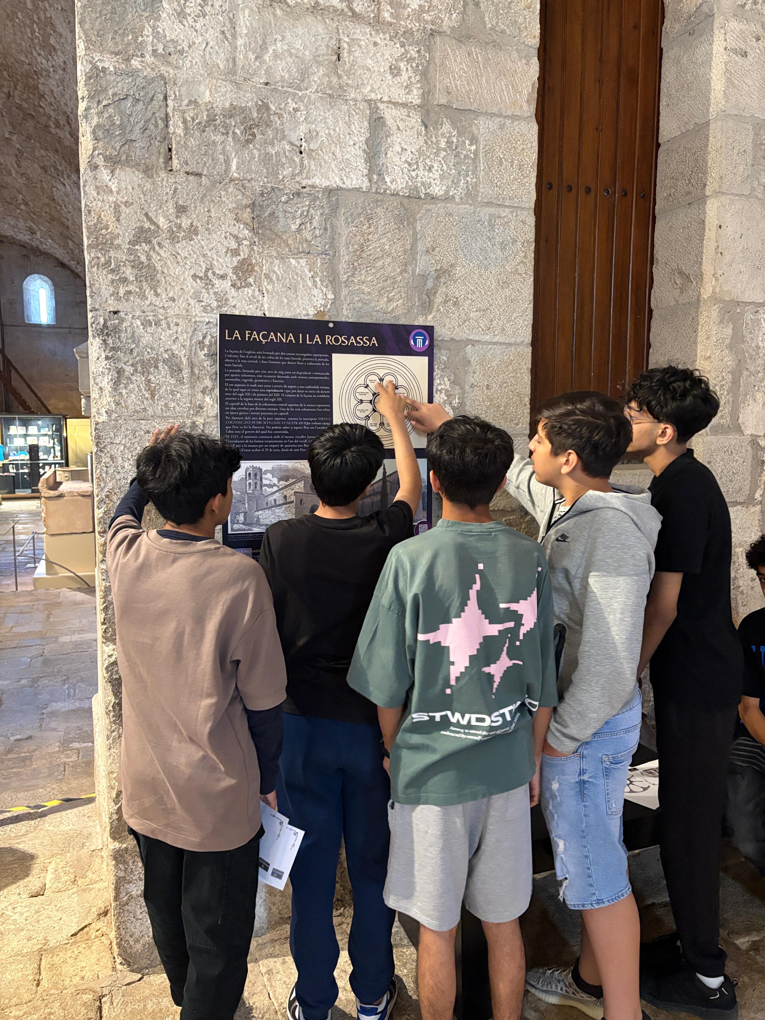 Grup d'adolescents observant un mapa dins una església.