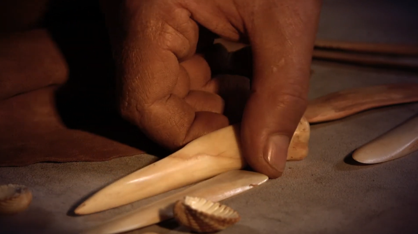 Mà agafant una eina prehistòrica.