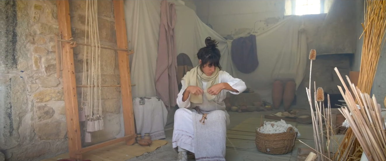 Una dona vestida d'època iber filant