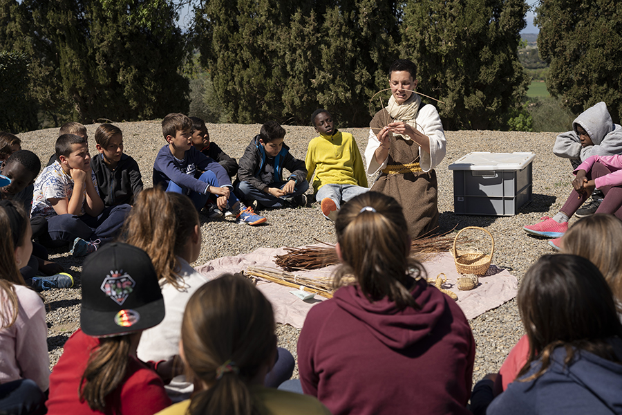 Explicació de com fer un cistell a un grup de nens